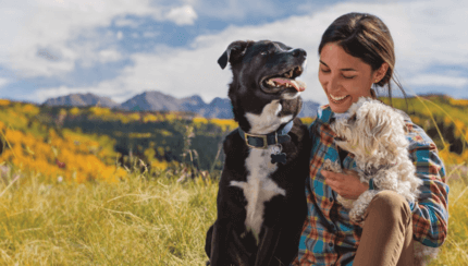 fiatal nő két kutyájával boldogan természetben